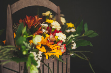 Flower arrangement with a sunflower on a black background. Macro photo. Stylish flowers for sale. Artistic style. Rustic style. Selective focus.