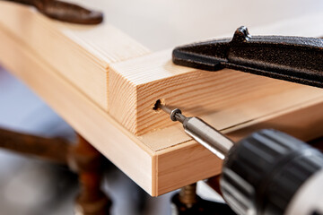 a screw is screwed into wood with a cordless screwdriver