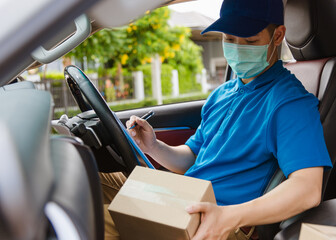 Asian delivery courier young man driver inside the van car with parcel post boxes checking amount he protective face mask, under curfew quarantine pandemic coronavirus COVID-19