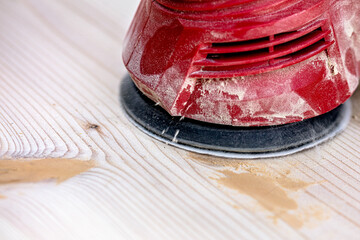 sanding a board with an random orbital sander or rotary sander