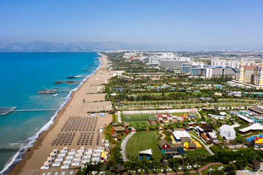Sandy beaches of the Mediterranean. Kundu holiday complex with five star hotels. Beach, sea, water sports, parasailing, entertainment and shopping center. Aerial view with drone. Kundu, Lara -TURKEY