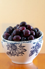 Large mug full of cherries on neutral background