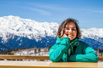 Fototapeta na wymiar Beautiful girl stay under panorama of Georgia mountains Uzhba and snow hat