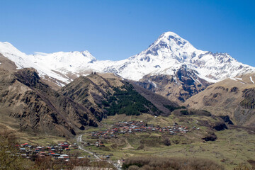 Fototapeta na wymiar panorama of Kazbek mountain village meadow and snow