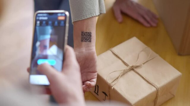 Close up of delivery person scan qr code on client hand