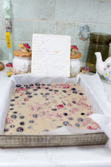 Preparation of cake with cherries and raspberries.