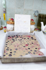 Preparation of cake with cherries and raspberries.