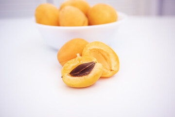 Naklejka na ściany i meble Apricot on a wooden white background. Sliced apricot, apricots in a plate, apricot slices