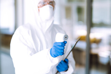 Disease control expert with an Infrared thermometer equipment to check the temperature at office. The concept of preventing the spread of the epidemic and treating coronavirus, pandemic in quarantine 