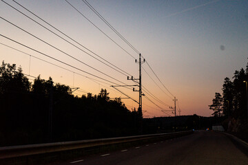 Fototapeta na wymiar Summer sunset with the train wires. Power lines. sunset.