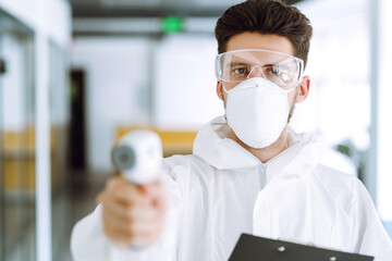 Disease control expert with an Infrared thermometer equipment to check the temperature. The concept of preventing the spread of the epidemic and treating coronavirus, pandemic in quarantine city. 