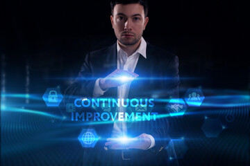 Business, Technology, Internet and network concept. Young businessman working on a virtual screen of the future and sees the inscription: Continuous improvement