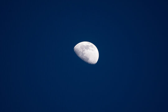 Close up of nice crescent moon on a dark blue sky. Stock photo of the details of the moon in the blue hour.
