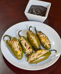Chiles jalapeños rellenos bañados acompañados de salsa