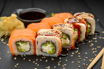 Sushi roll with eel and salmon on black background