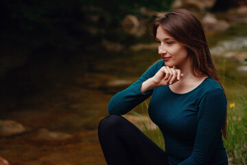 Female tourist in the forest resting near the river