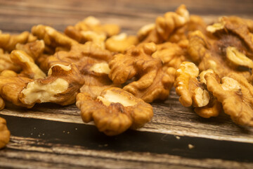 Peeled walnuts scattered on a wooden table. Healthy diet. Fitness diet. Close up.