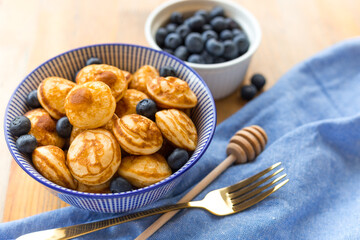 Mini cereal pancakes with berries on wooden table. Trendy food concept, Breakfast time for kids. Menu, recipe, top view or flat lay