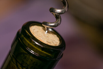 Extremely close up view of bottleneck of wine bottle and bottle-screw swirling cork. Wine bottle...