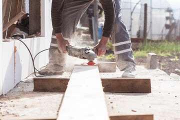 Man hands hold an old machine that grinds boards.