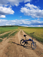 Fototapeta na wymiar Bike stands on a country road in field