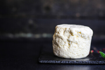 cheese head and slices pickled Adyghe or Suluguni Menu concept camembert or brie serving size. food background top view copy space for text organic healthy eating keto or paleo diet