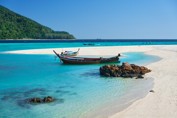 Fototapeta na wymiar Boat on tropical white sandy beach and turquoise water