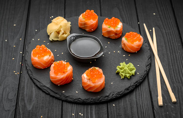 salmon sushi rolls on black background.