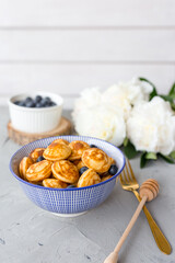 Mini cereal pancakes with blueberries in a bowl on gray background. Trendy food concept, Breakfast time for kids. Menu, recipe