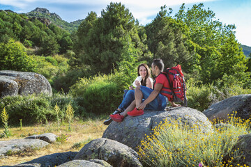 Couple hiking in the mountains resting and drinking water