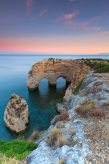 Fototapeta na wymiar Algarve in Portugal and its amazing beaches, is a summer holiday destination for many tourists in Europe. Landscape with cliffs on the coast at colorful sunset. Pure nature, blue sea, sand.