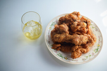 Beer with fried chicken on a plate on a white background