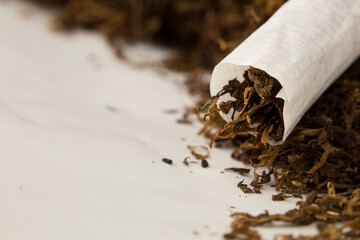 macro photo of hand rolled tobacco in its leaves. there is space in the photo for text.	