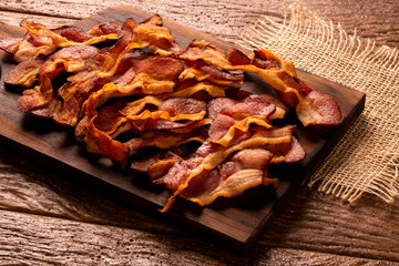 fried bacon strips on rustic wooden board