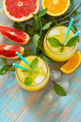 Summer drink. Orange and Grapefruit  refreshing drink with ice. Top view flat lay background. Copy space.
