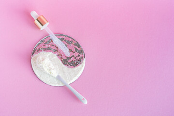 Collagen powder and serum on a pink background. Internal and external cosmetic procedure for young skin and a healthy body. Creative yin yang concept. Flatlay, top view. Copy space