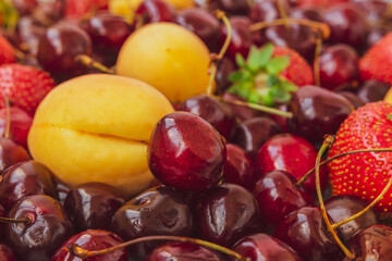 Fresh juicy fruits. Cherries, strawberries and apricots. A set of vitamins and nutrients. Immune strengthening products. Front view. Color photo of fruits. Set of summer berries. Healthy eating.
