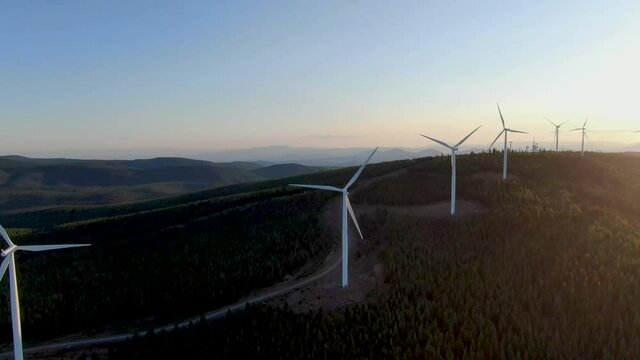 Sunsetting behind many wind energy converters.