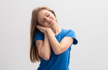 smiling blonde caucasian model is pretending to sleep isolated on white studio background.