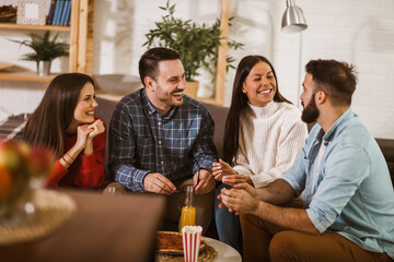 Group of young friends eating pizza in home interior.  Young people having fun together.