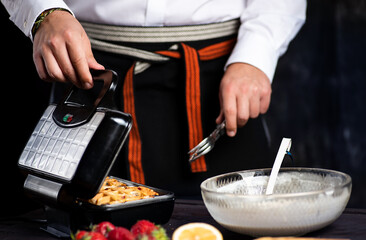 Man making waffles on a waffle machine