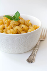 Simple American stove-top elbow macaroni and cheese also called mac n cheese garnished with basil...
