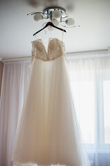wedding dress on a hanger, gathering the bride