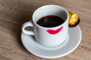 White mug with coffee in red lipstick.