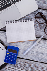 Top view office and finance accessories and notepad for copy space. White wooden table.