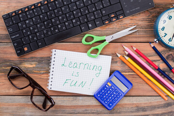 School accessories and learning is fun note. Top view flat lay.