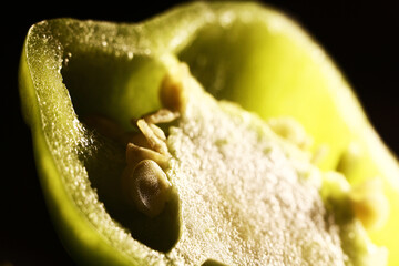 Half ripe green pepper on the table in the kitchen. Ingredient for cooking roast. Juicy bell pepper with seeds