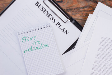 Flat lay different paper document and notebook. Time for motivation written on notepad.