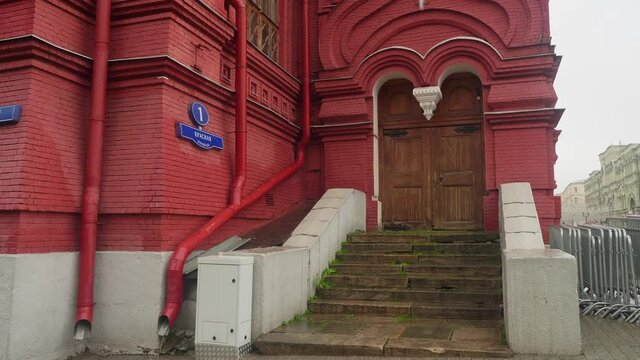 Red building with stairs leading to door and writing on the wall meaning adress Red Square 1