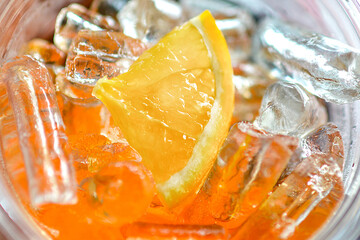 Fototapeta na wymiar Fresh orange in ice cubes background. 
